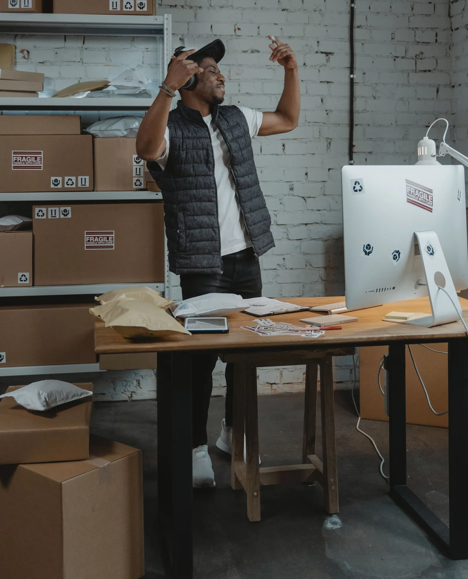 A seller celebrating at a packing desk, surrounded by parcels ready to ship